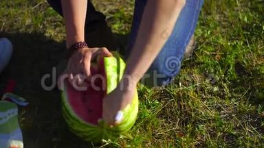 年轻人和女人在河边的森林里野餐<strong>吃西瓜</strong>。 切<strong>西瓜</strong>的特写.. 4千克